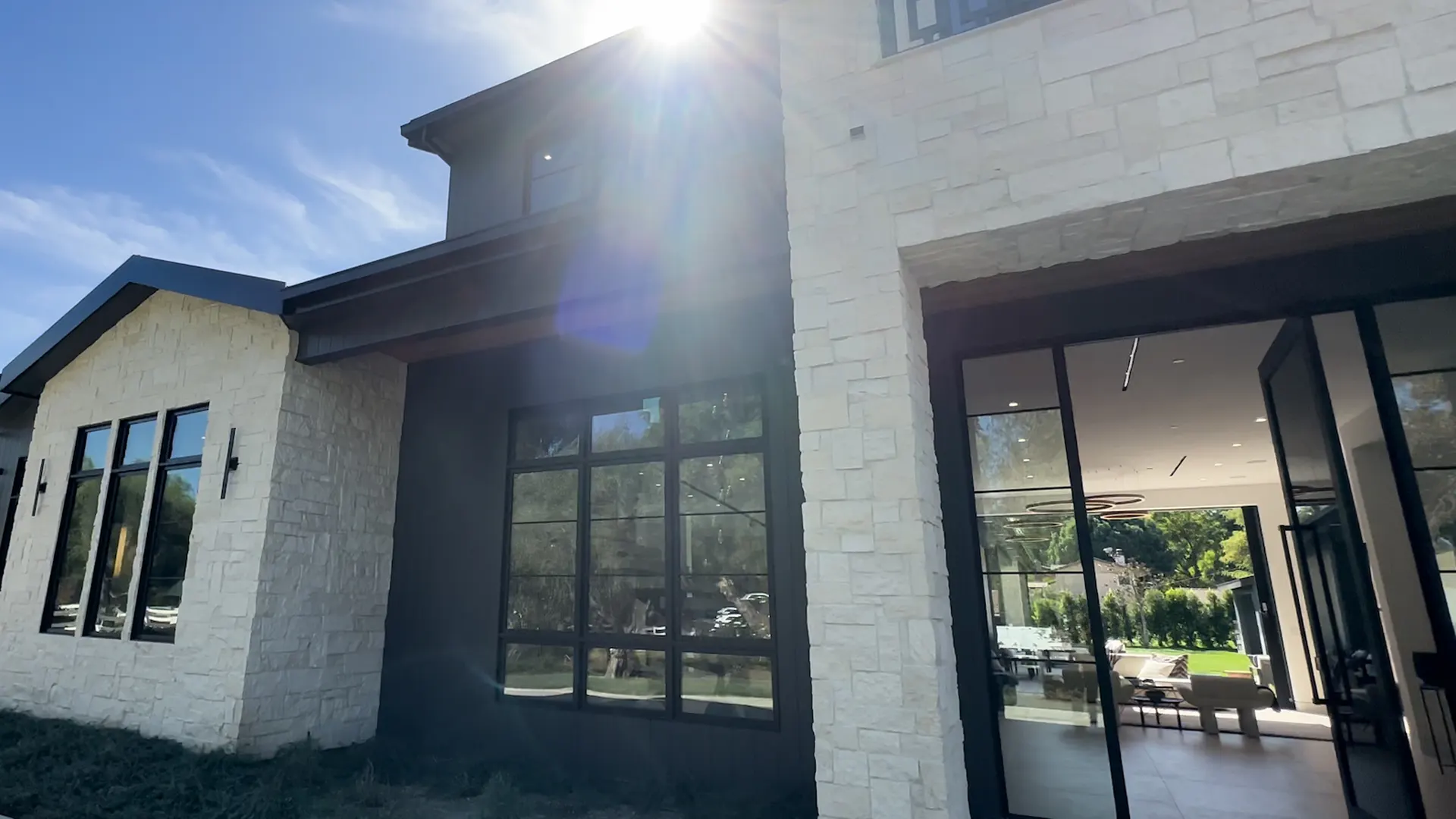 Modern home exterior with new roof, stone façade and landscaping