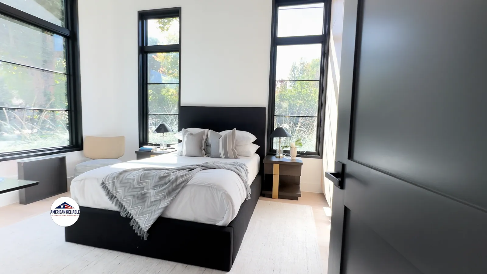 Modern master bedroom with black frame windows and natural light