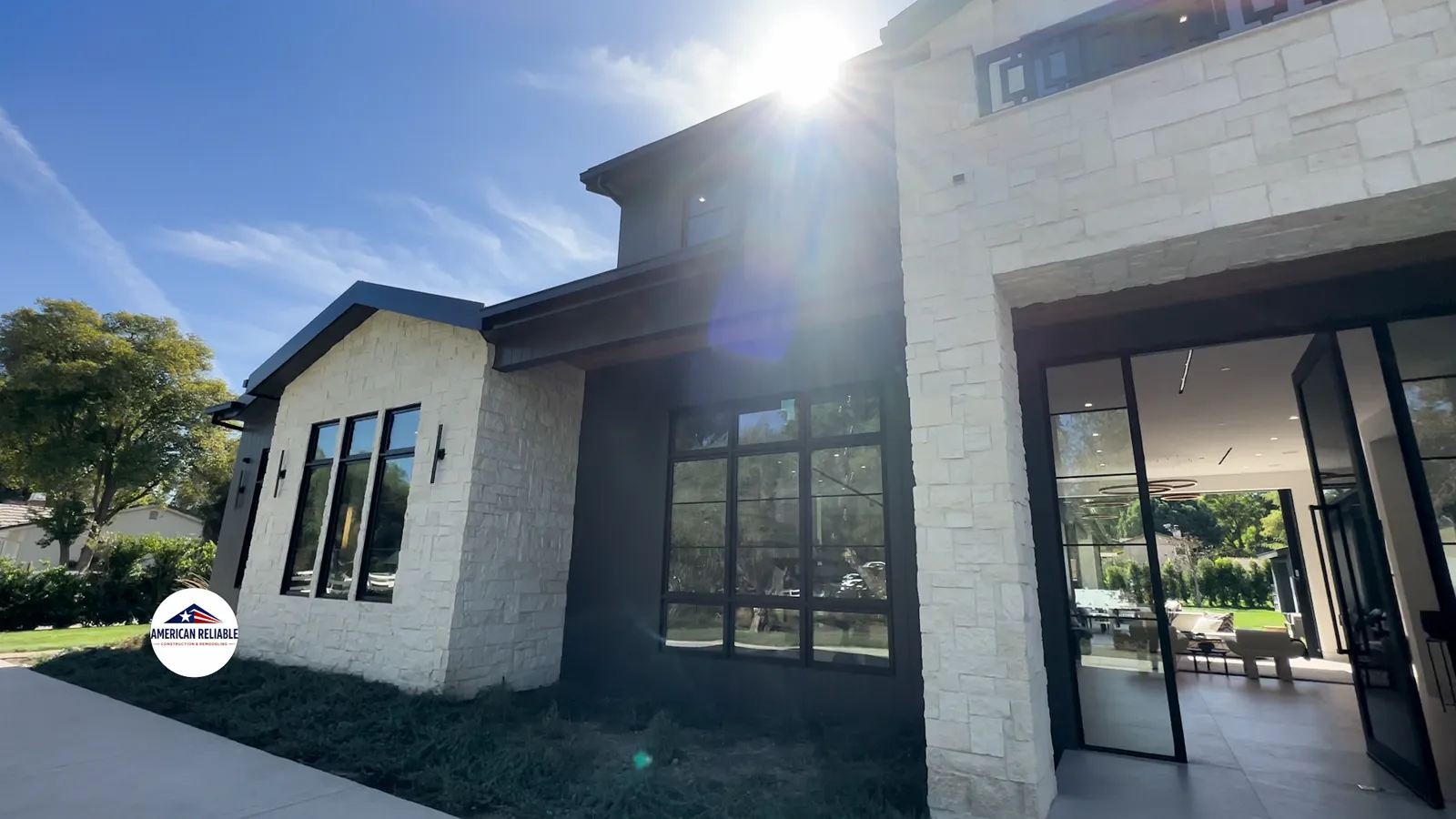Modern home exterior with new roof, stone façade and landscaping