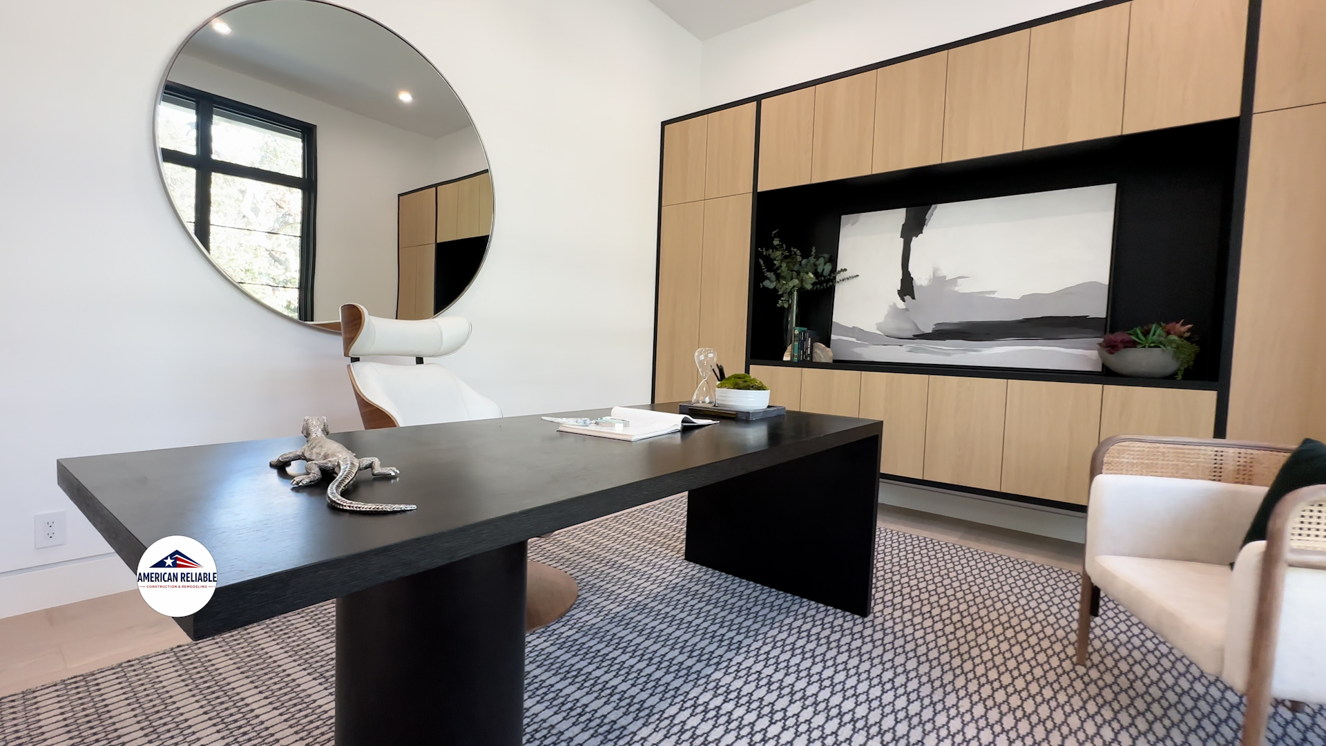 Modern office with black desk and round mirror