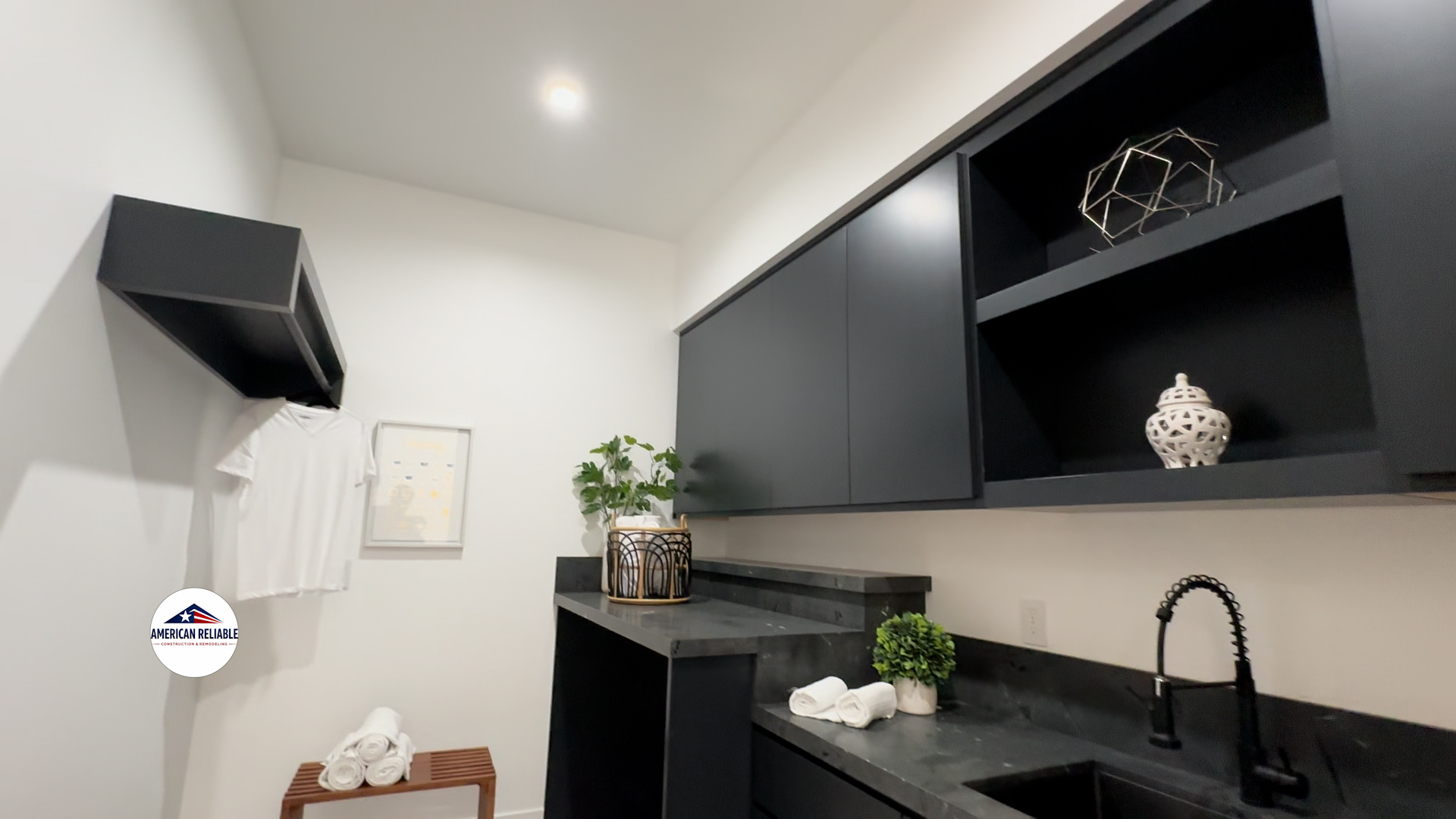 Modern laundry room with dark custom cabinetry