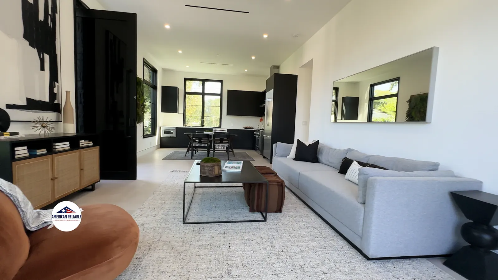 Open-plan living and kitchen after a whole-home renovation — black steel windows, white oak floors and a garden view