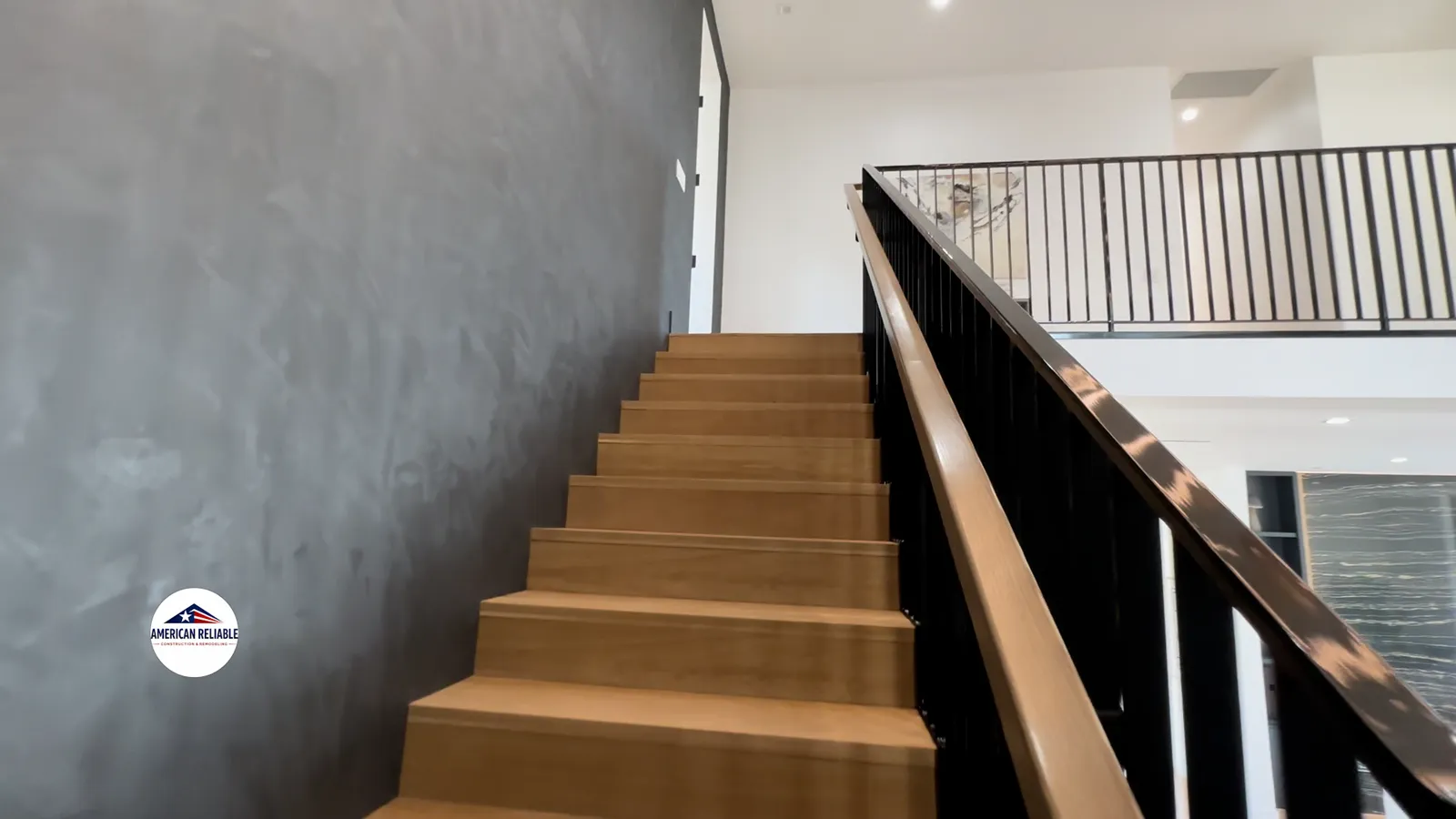 Custom oak staircase with venetian plaster accent wall